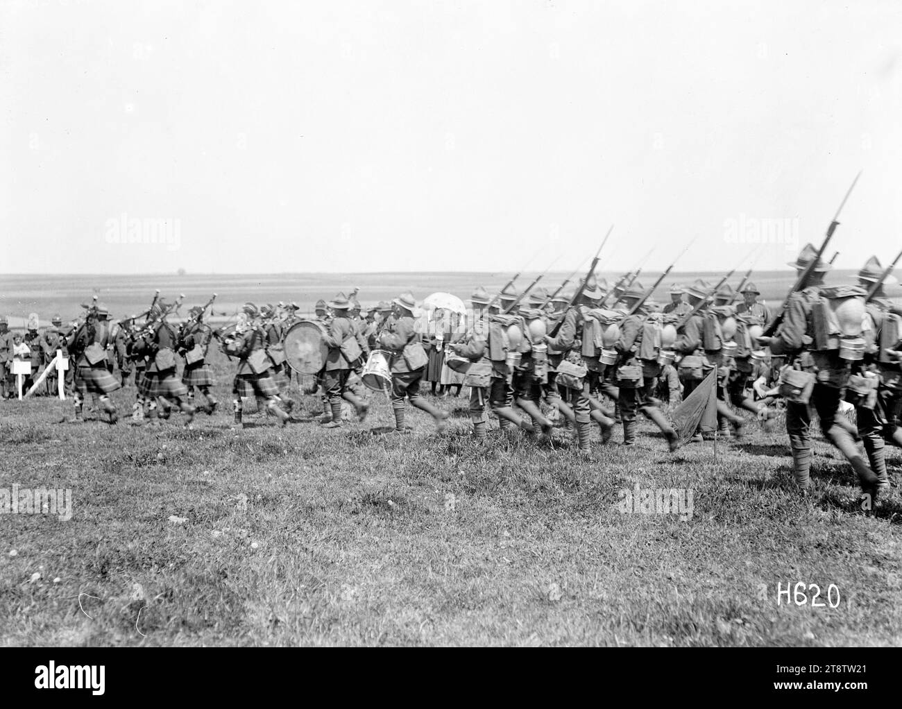 Interpretando i vincitori di un evento al New Zealand Infantry Brigade Horse Show, Francia, Una banda di tubi che suona i vincitori della gara di montaggio della guardia intorno all'anello dello spettacolo al New Zealand Infantry Brigade Horse Show, Vaucelles, durante la prima guerra mondiale Il successo dell'Otago Regiment marcia dietro la band. Fotografia scattata il 20 maggio 1918 Foto Stock