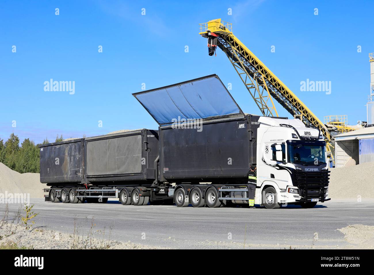 Il conducente del veicolo Scania 560R chiude il tetto del rimorchio dopo aver caricato un aggregato di vetro espanso nello stabilimento di produzione Uusioaines Oy. Forssa, Finlandia. 9 settembre 2022. Foto Stock