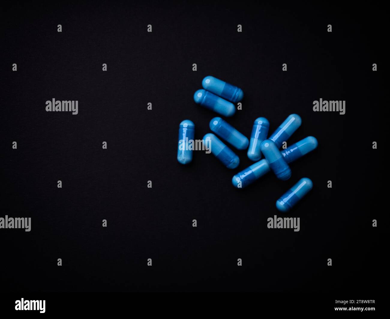 Capsule di aminoacidi su sfondo di carta scura. Messa a fuoco morbida. Vista dall'alto. Primo piano. Copia spazio. Foto Stock