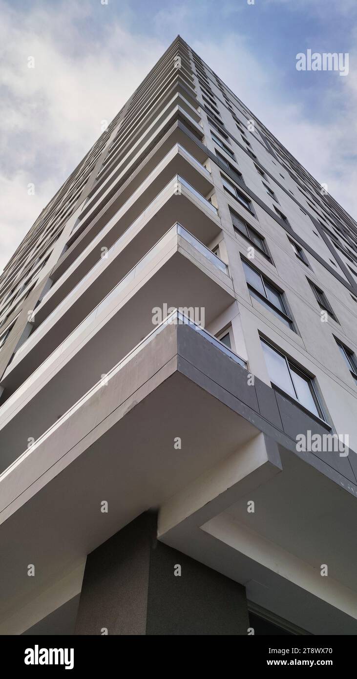 Edificio a più piani visto dal basso e all'angolo in un pomeriggio nuvoloso Foto Stock