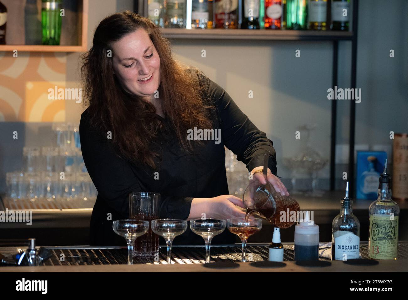 21 novembre 2023, bassa Sassonia, Göttingen: Kamma Romy Hogeveen di Colonia prepara un cocktail al 37° Campionato tedesco di cocktail. I baristi di tutta la Germania competono nella bassa Sassonia meridionale. Presentano le loro creazioni precedentemente presentate a una giuria. Foto: Swen Pförtner/dpa Foto Stock