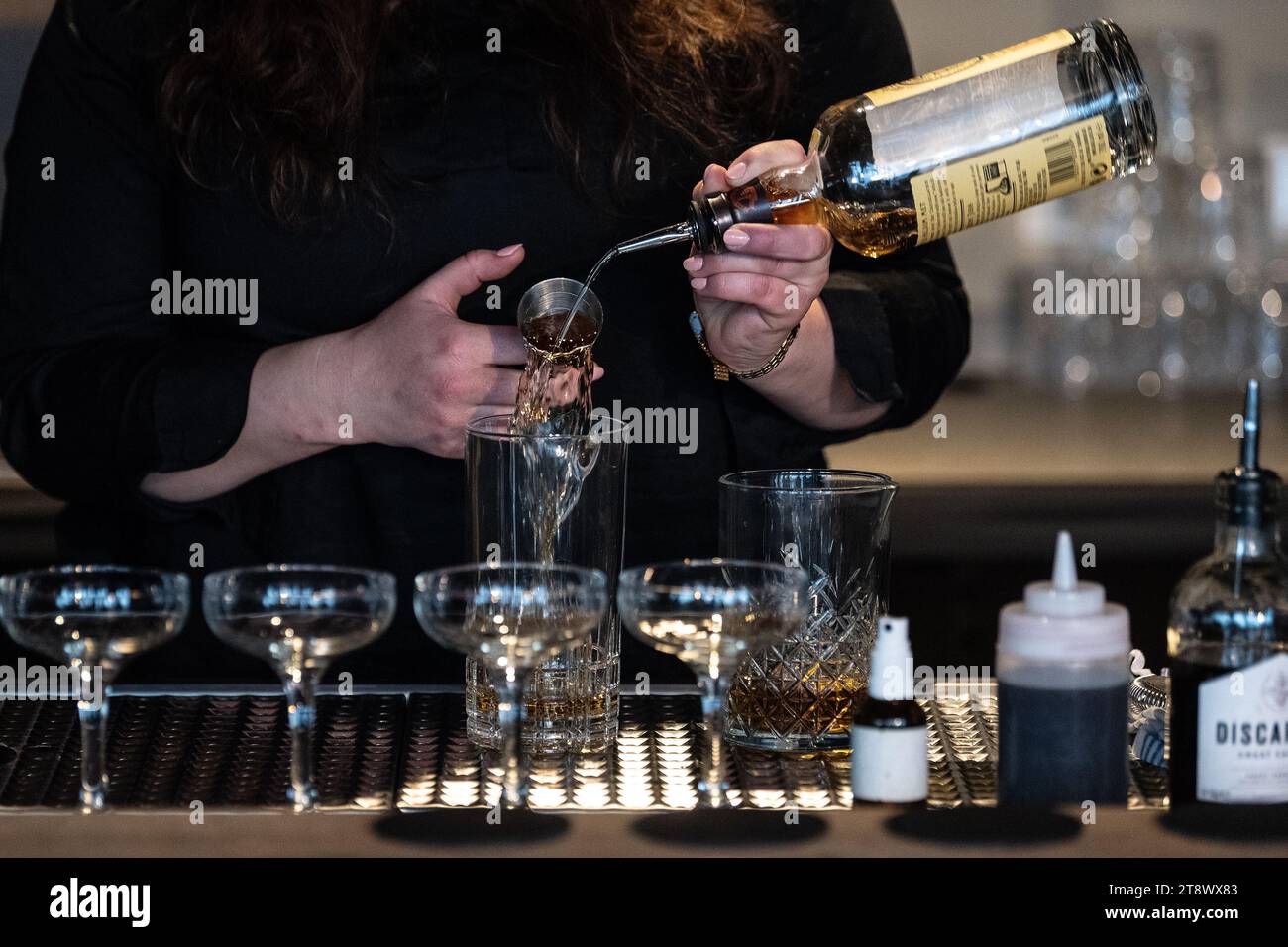 21 novembre 2023, bassa Sassonia, Göttingen: Kamma Romy Hogeveen di Colonia prepara un cocktail al 37° Campionato tedesco di cocktail. I baristi di tutta la Germania competono nella bassa Sassonia meridionale. Presentano le loro creazioni precedentemente presentate a una giuria. Foto: Swen Pförtner/dpa Foto Stock