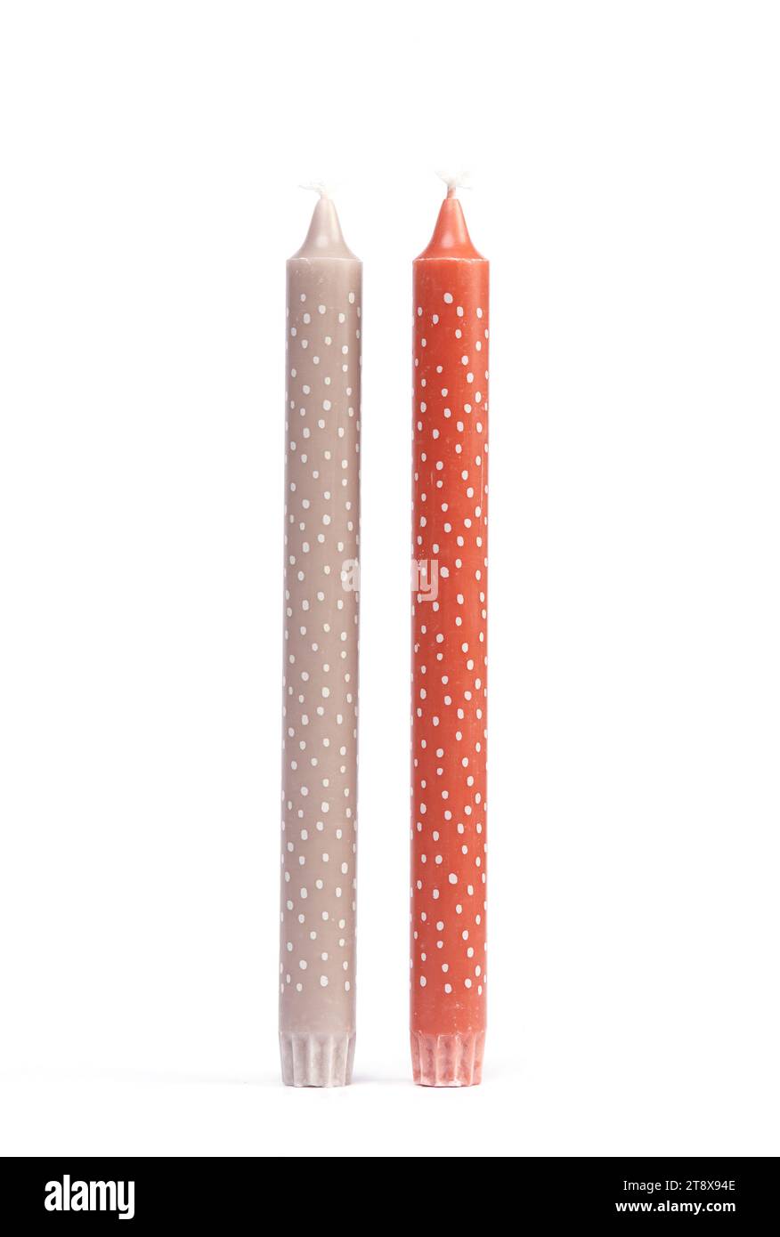 Candele alte e sottili di Natale rosse e beige con pois a pois isolato su sfondo bianco. Foto Stock