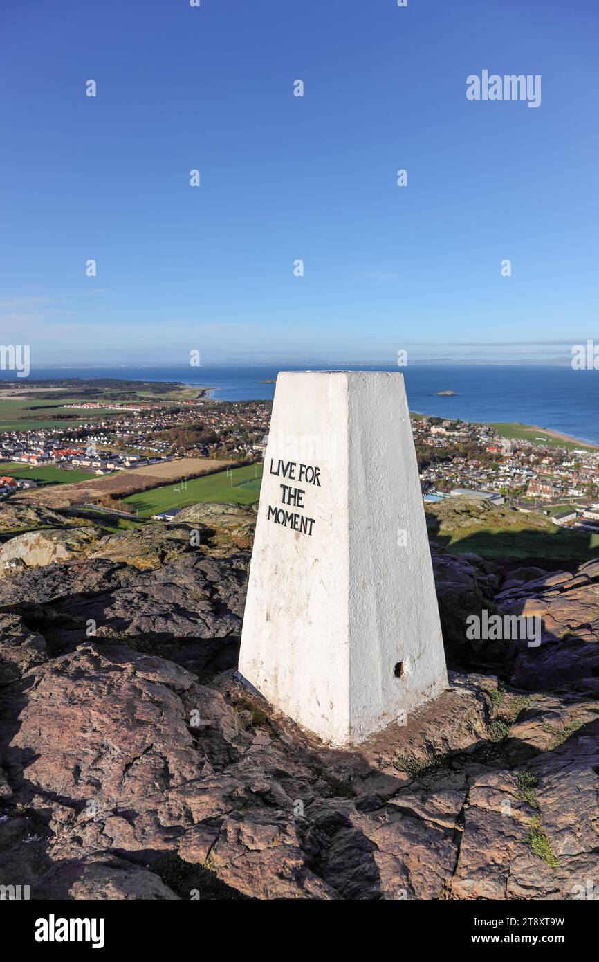 Il Summit Trig Point sulla legge di North Berwick con il messaggio “Live for the Moment”, North Berwick, East Lothian, Scozia, Regno Unito. Foto Stock