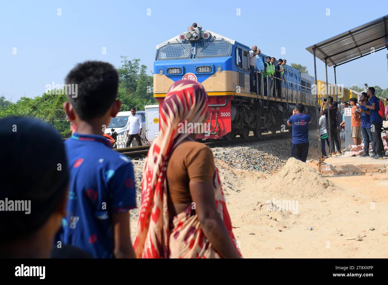 Gli indiani guardano un treno di prova e scattano fotografie, che sta attraversando il confine Indo-Bangladesh. Il treno partì dalla stazione di Gangasagar in Bangladesh e raggiunse la stazione di Nischintapur per la prima volta alla periferia di Agartala. Tripura, India. Foto Stock