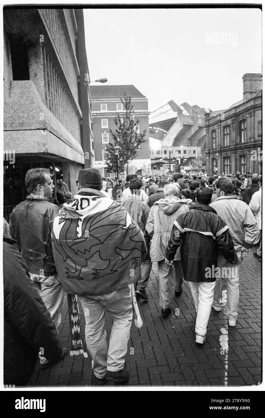 I tifosi si dirigono lungo Quay Street verso Westgate Street con le iconiche braccia di cemento del vecchio stadio all'orizzonte. Qualificazioni al gruppo 4 della Coppa del mondo FIFA 1994 – Galles contro RCS (Cecoslovacchia AKA Representation of Czechs and Slovaks) al Cardiff Arms Park, Galles, Regno Unito l'8 settembre 1993. Una vittoria per il Galles in questa partita avrebbe quasi garantito la qualificazione con 2 partite a gironi rimanenti. Hanno guidato 2-1 ma hanno concesso un gol di punizione da Peter Dubovský e la partita è finita 2-2. Foto: Rob Watkins Foto Stock