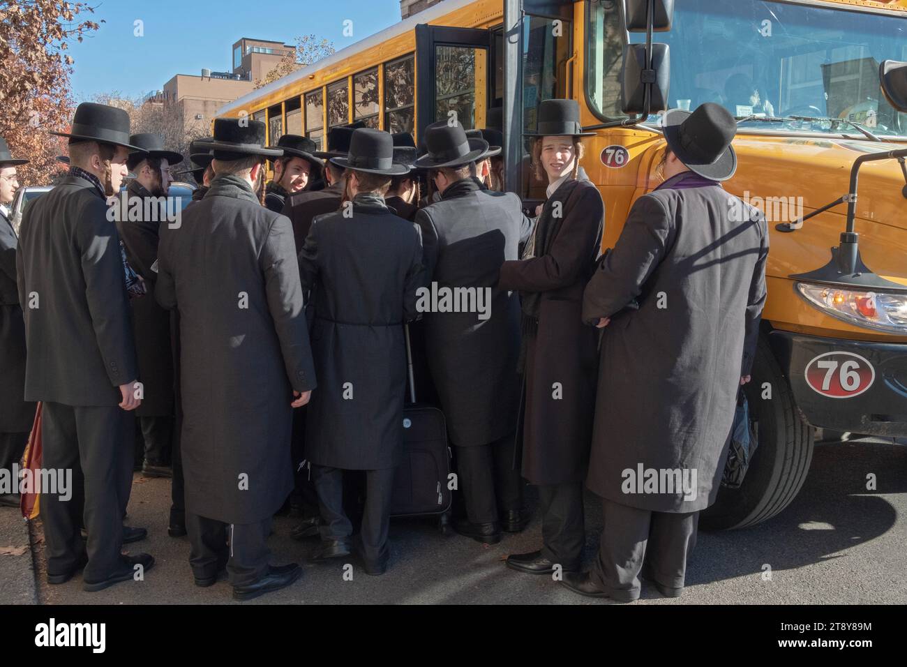 Un grande gruppo di ebrei satmar ultra ortodossi di Williamsburg sale a bordo di un autobus per andare a un seminario sul Talmud in un altro quartiere. 19 novembre 2023. Foto Stock