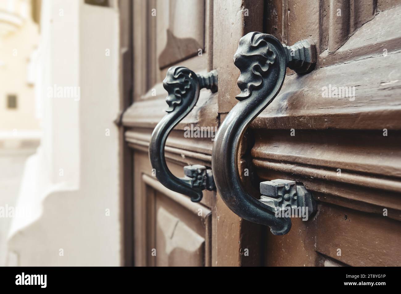 Le maniglie delle portiere vintage rétro si avvicinano. Vecchia porta in legno con bellissimi pomelli retrò. Messa a fuoco selettiva. Foto Stock