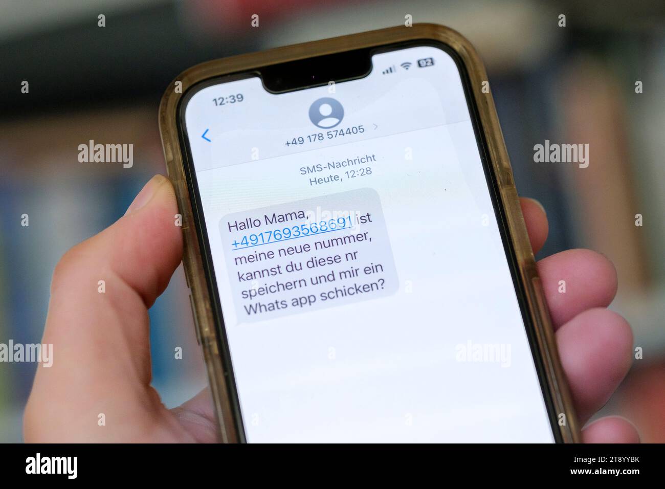 Hand tiene un telefono cellulare con un messaggio WhatsApp, che è l'inizio di un caso di truffa di Messenger Foto Stock