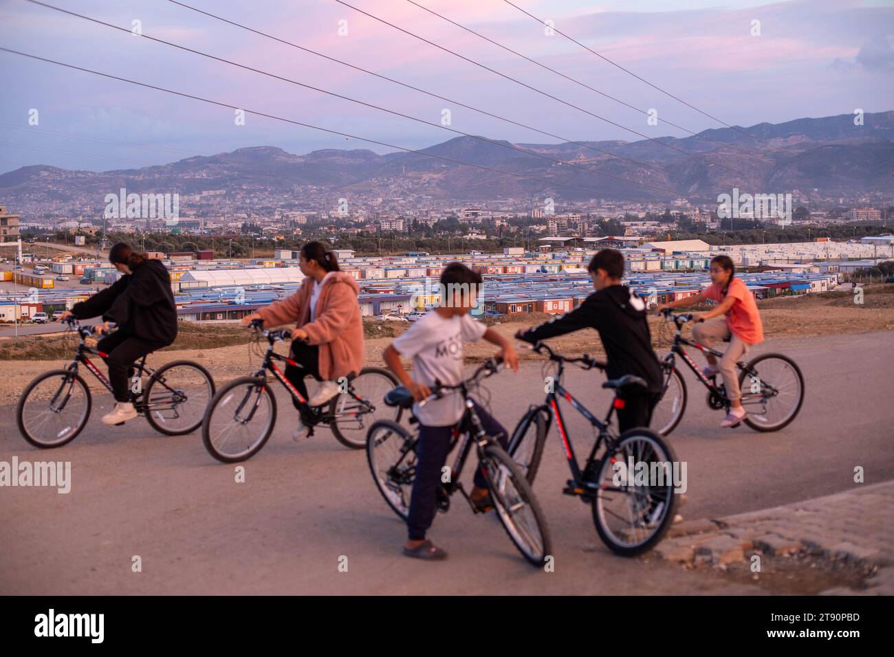 Antakya, Hatay, Turchia. 3 novembre 2023. I bambini vanno in bicicletta donati da organizzazioni di beneficenza internazionali vicino alla città container nel quartiere di Kuzeytepe che attualmente chiamano casa. Circa 150 mila persone che hanno perso le loro case ora vivono in decine di città container istituite intorno al distretto di Antakya, che è stato dedicato dopo i terremoti. Fondata dall'AFAD, la Presidenza di gestione delle emergenze e dei disastri è una delle più grandi di Hatay, con una popolazione di oltre 10 mila abitanti. (Immagine di credito: ¬ © tolga Ildun/ZUMA Press Wire) SOLO USO EDITORIALE! Non per Comme Foto Stock