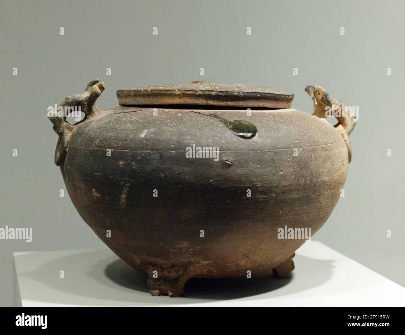 Vaso coperto, IV secolo a.C., 6 x 10 3/8 pollici (15,2 x 26,35 cm) (a: vaso)3/4 x 7/8" (1,91 x 14,92 cm) (b: Coperchio), gres con smalto "accidentale", Cina, IV secolo a.C., realizzato a imitazione di un vaso di bronzo rituale, questo gres a fuoco alto è smaltato tranne che per alcuni spruzzi accidentali di smalto verde sul coperchio. Durante tutto il periodo Zhou, il grès impressionato e ad alto fusto continuò ad essere raffinato, specialmente nei tratti inferiori dello Yangzi e delle province sud-orientali. Per molti anni, le pietre smaltate e non smaltate sono rimaste simili nella tecnica e nella decorazione. Foto Stock