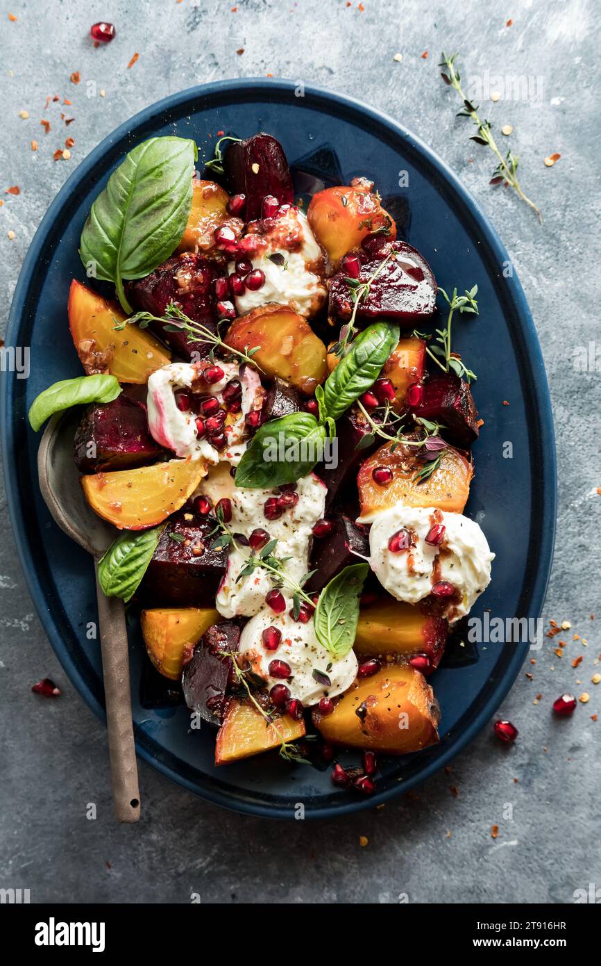 Un piatto di barbabietole arrostite con burrata, erbe e arils di melograno. Foto Stock