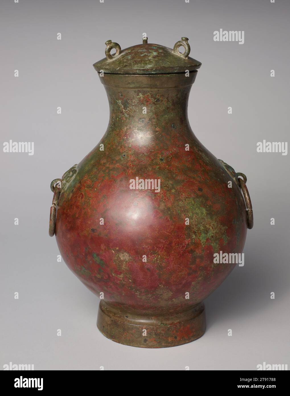 HU copriva navi, III secolo a.C., 13 7/8 x 8 7/8 pollici (35,2 x 22,54 cm), Bronzo, Cina, III secolo a.C., il vino hu o vaso d'acqua si è evoluto dalla tarda Shang (1300–1046 a.C. circa) alle dinastie Han (206 a.C.–220 d.C.) e ha assunto una grande varietà di forme. Durante il periodo degli Stati combattenti, questo tipo di hu rotondo, con la sua pancia rigonfiata, il collo alto e il piede rigato, divenne uno dei vasi di bronzo più popolari. In linea con il gusto contemporaneo, era relativamente non decorato, a volte con l'eccezione di diverse corde di fiocco rialzate, o bande piatte, che circondano il corpo. La maggior parte di essi dispone di maniglie ad anello Foto Stock