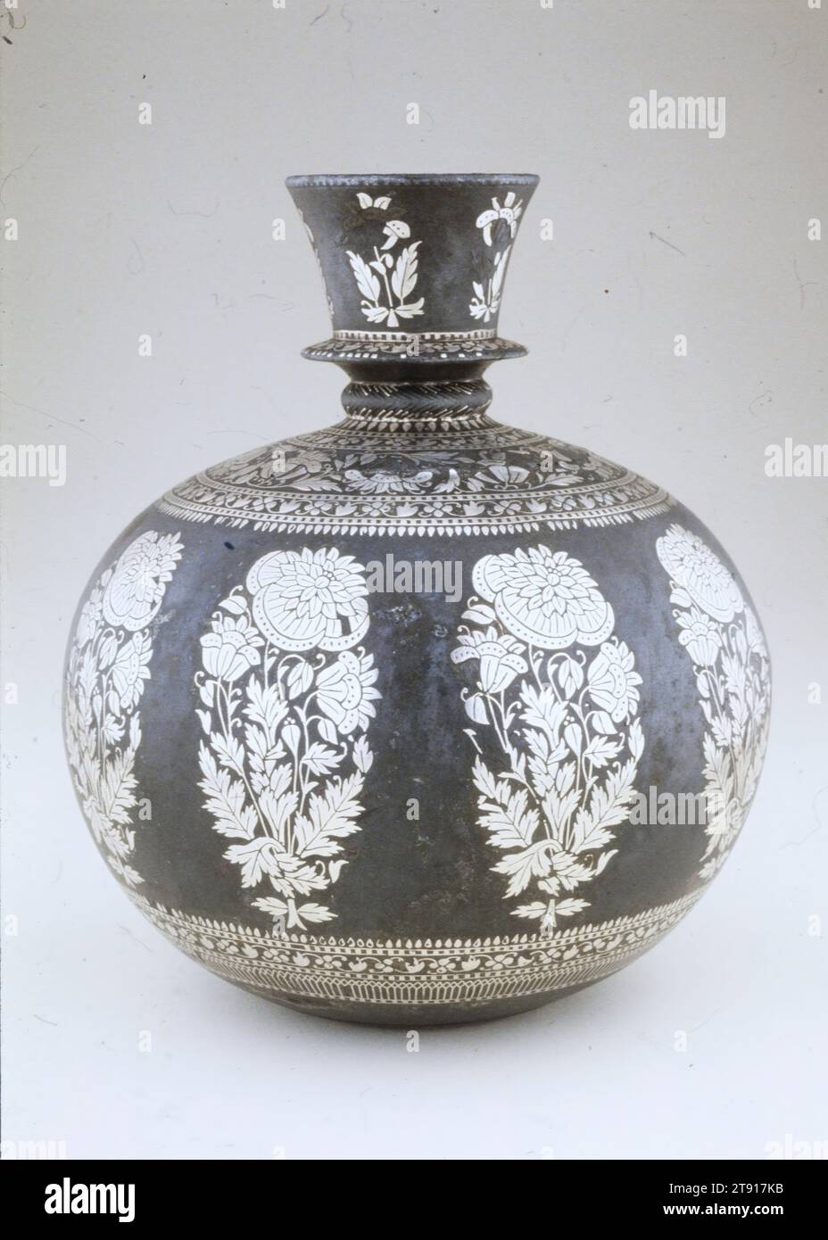 Base per un tubo dell'acqua, XVIII secolo, 6 1/2 x 5 1/2" (16,51 x 13,97 cm), lega di zinco; colata, incisa, argentata, India, XVIII secolo, Water Pipes (narghilè) sono stati usati per fumare tabacco dal XVII secolo in poi. L'utilizzatore di narghilè avrebbe fumato da un lungo tubo che si estendeva dalla base. Una fila ordinata di "papaveri Hyderabad" adorna il corpo globulare, un motivo popolare che appare anche nei tessuti e nei dipinti Foto Stock