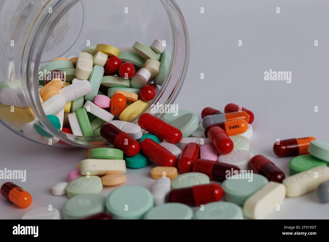 fuoriuscite di vari tipi di farmaci chimici da contenitori per medicinali su sfondo bianco. Foto Stock