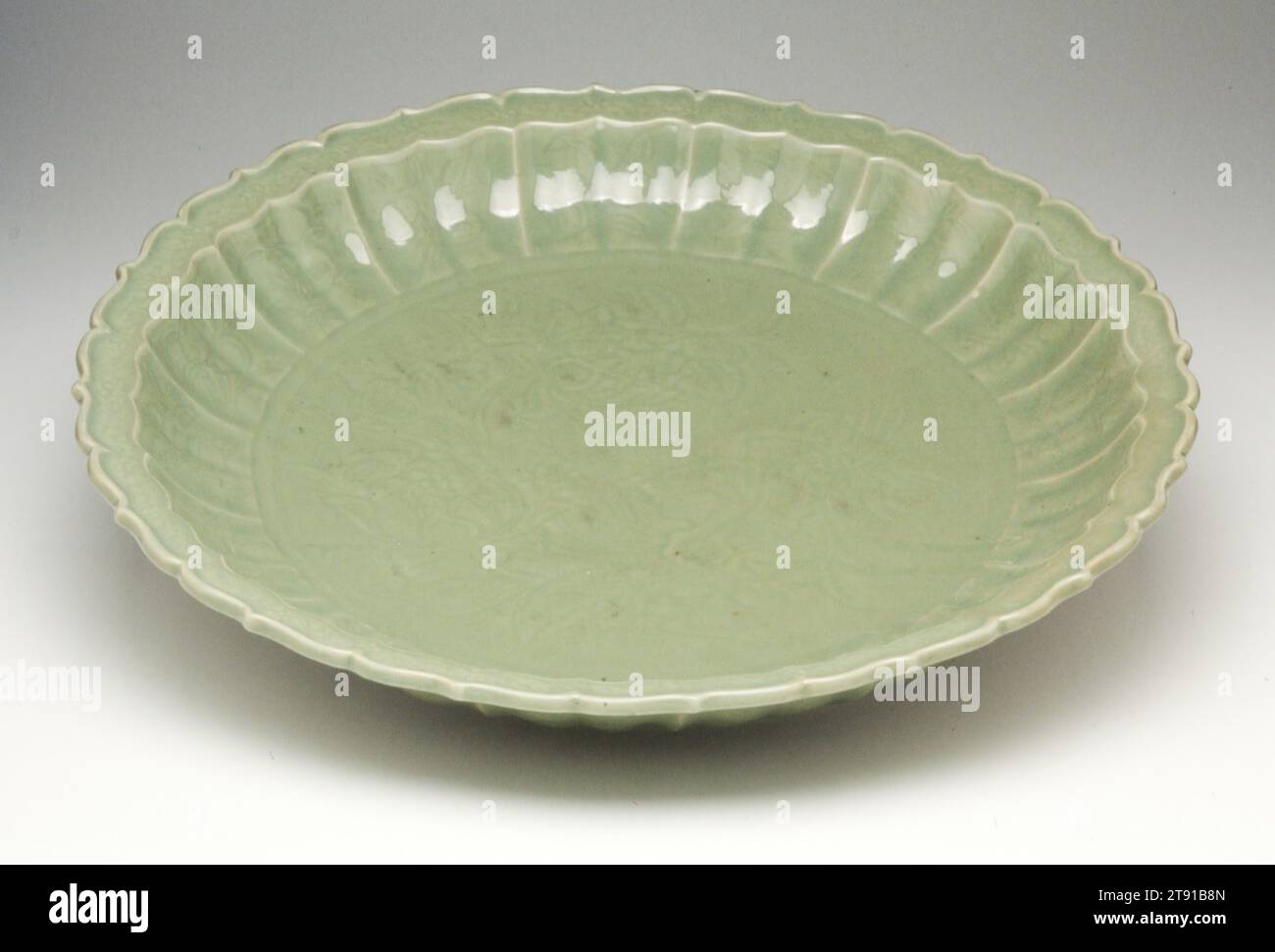 DISH, inizio XV secolo, H.4 x dia.21-5/8 poll., gres porcellanato con glassa celadon, Cina, XV secolo, il distretto di Lung-ch'uan nella provincia di Chekiang fu un importante centro di produzione di celadon dalle cinque dinastie (907-960) fino al periodo Ming (1368-1644). Celadon è semplicemente un termine descrittivo applicato alle ceramiche che rientrano in un'ampia gamma di colori da blu-verde a grigio-verde. Il celadon è stato prodotto in Corea, Giappone, Thailandia ed esportato dalla Cina in India, Persia, Turchia, Egitto e Sud-Est asiatico. Foto Stock