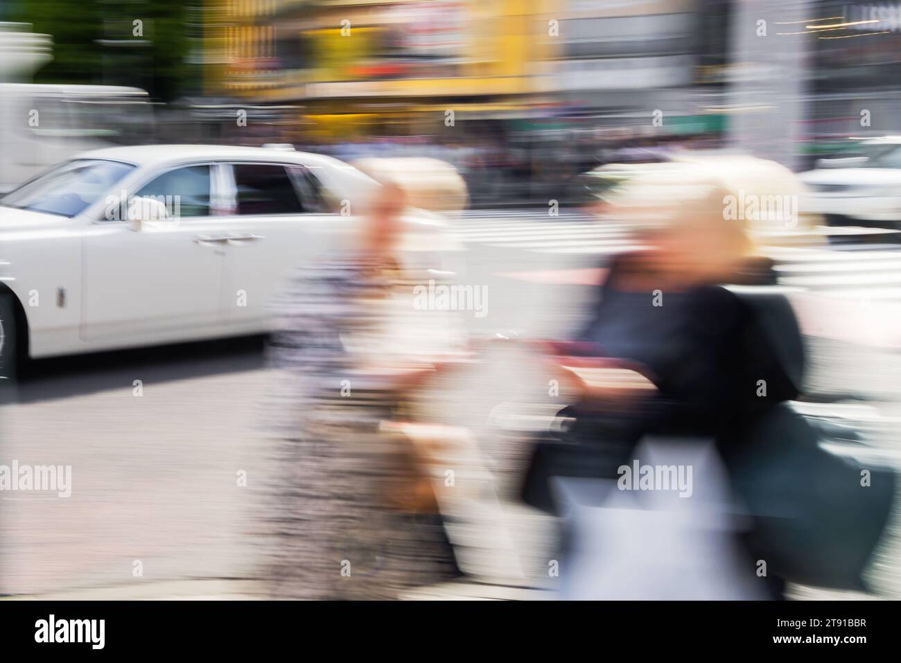 immagine astratta con effetto di sfocatura del movimento intenzionale delle donne che camminano nel traffico cittadino Foto Stock