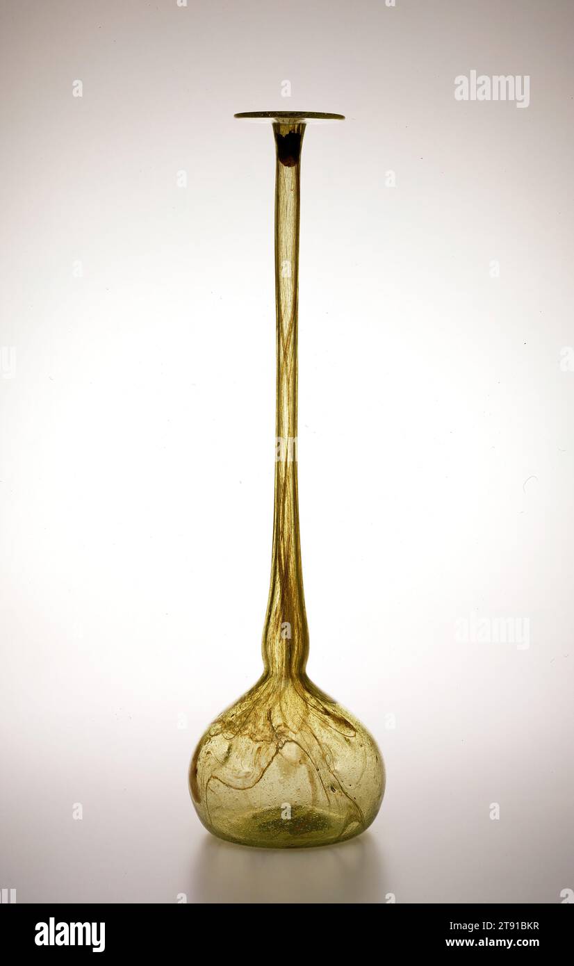 Vaso Clutha, c. 1885, Christopher Dresser; produttore: James Couper and Sons, scozzese, 1834-1904, 20 1/4 x 5 5/8 x 5 5/8 pollici (51,44 x 14,29 x 14,29 cm) (al collo), vetro soffiato, Inghilterra, XIX secolo, il primo designer industriale moderno, Christopher Dresser ha lavorato con diversi produttori britannici di mobili, lavori in metallo, carta da parati, ceramica e vetro per creare oggetti ben progettati ma di produzione di massa. Per l'azienda scozzese James Couper and Sons progettò una linea di vetro soffiato a mano prodotto con tecniche industriali. La linea era chiamata Clutha, che significa "nuvoloso" in gaelico Foto Stock