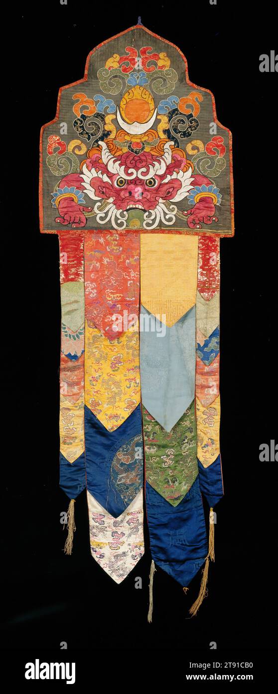 Banner del tempio, inizio XIX secolo, 70 x 24 pollici (177,8 x 60,96 cm), broccato di seta, damascato e appliqué, Tibet, nel XIX secolo, il sacerdozio tibetano usava estesamente sete importate dalla Cina per decorare i loro monasteri. Gli interni del tempio erano eccezionalmente colorati con le loro tettoie di seta, striscioni e frontali degli altare. Questo striscione è tipico di quelli che erano sospesi da pilastri o appesi alle staffe del tetto nelle sale immagini e nelle sale conferenze. La sezione inferiore, realizzata con diversi tipi di frammenti di seta, ha motivi cinesi di buon auspicio come draghi, nuvole, pipistrelli e fiori di loto Foto Stock