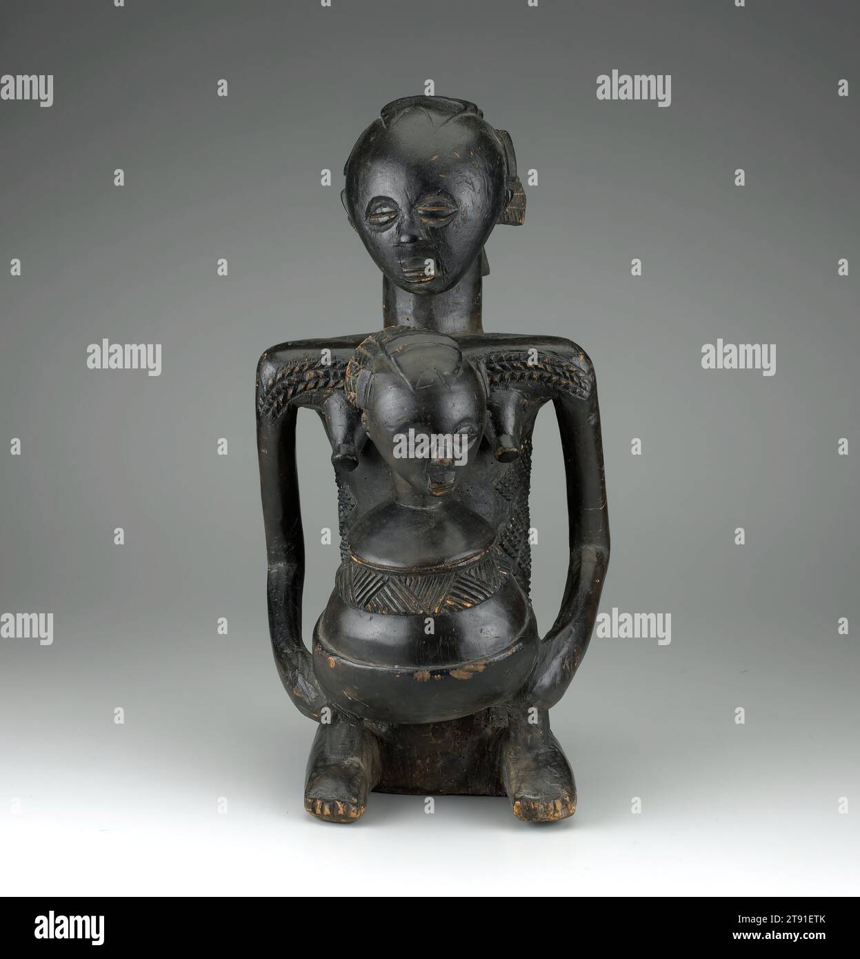 Figura, c. 1900, 20-1/4 x 9-1/2 x 9-3/8 pollici (51,4 x 24,1 x 23,8 cm), legno, Repubblica Democratica del Congo, XIX-XX secolo, gli artisti Luba più frequentemente incisero figure femminili. Le donne detenevano una posizione forte nella società Luba e svolgevano una varietà di ruoli sociali, spirituali e politici. Erano associati a cerimonie sacre e agli antenati e si credeva che avessero un potere protettivo e ringiovanente. Questa scultura, chiamata kabila o mboko, rappresenta una donna inginocchiata con un vaso in grembo. Il suo status elevato è indicato dalla sua elaborata coiffure e dalla scarificazione del corpo. Foto Stock