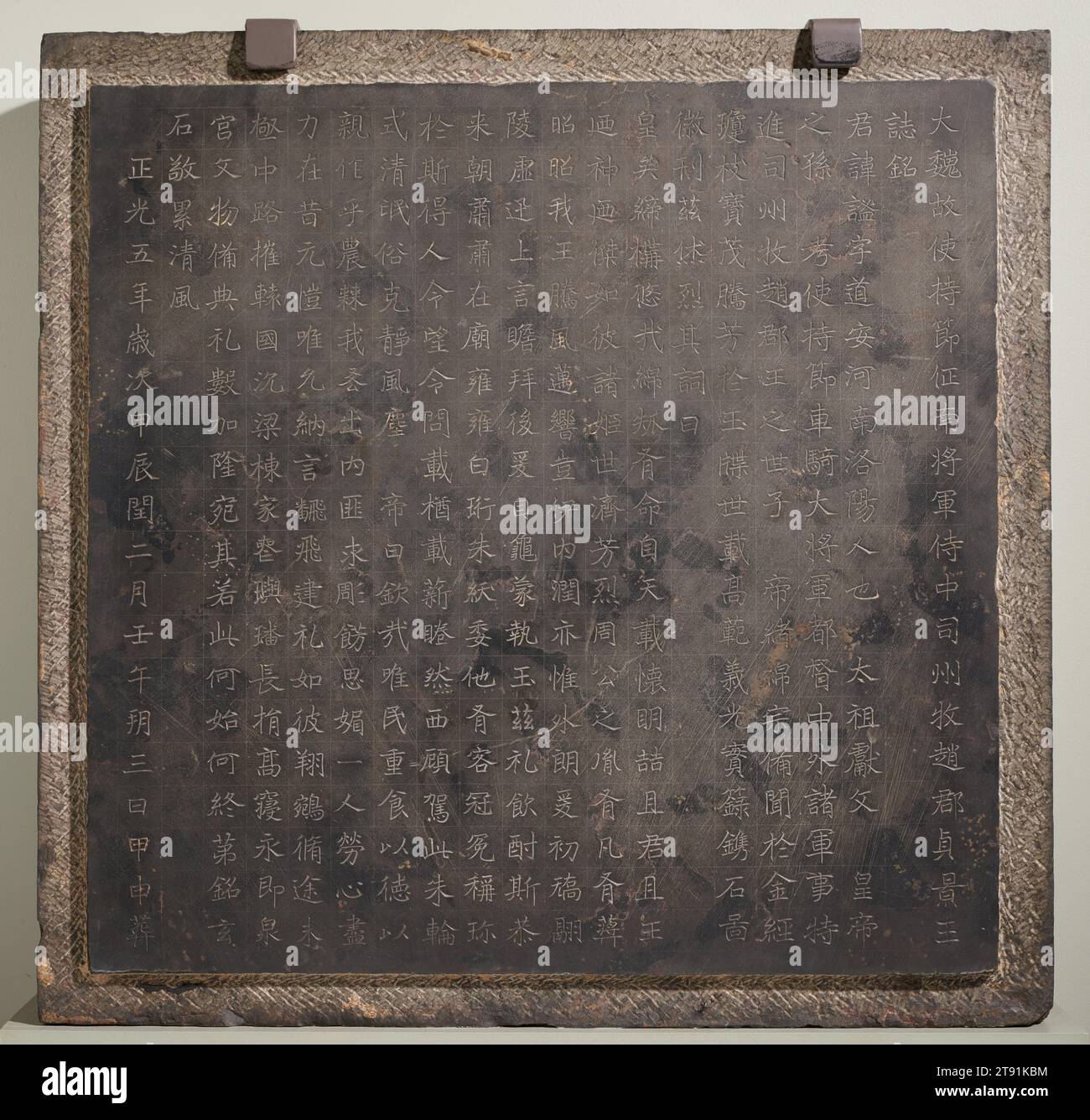 Copertina epitaffica di Prince Yuan mi, 524, 39 x 40 x 1/4 poll. (99,06 x 101,6 x 23,5 cm), calcare nero, Cina, vi secolo, questa tavoletta epitaffica, un testamento dell'arte della calligrafia cinese, è costituito da tre parti fondamentali: (1) il titolo ufficiale del principe Zheng Qing, che era zio del nono sovrano di Wei, l'imperatore Zheng Guang (520-524); (2) l'elogio imperiale e il decreto commemorativo, composto da suo nipote l'imperatore; (3) la data della sepoltura, il terzo giorno del secondo mese del quinto anno di Zheng Guang (524). Come dice il memoriale, il principe era il nipote del sesto imperatore Foto Stock