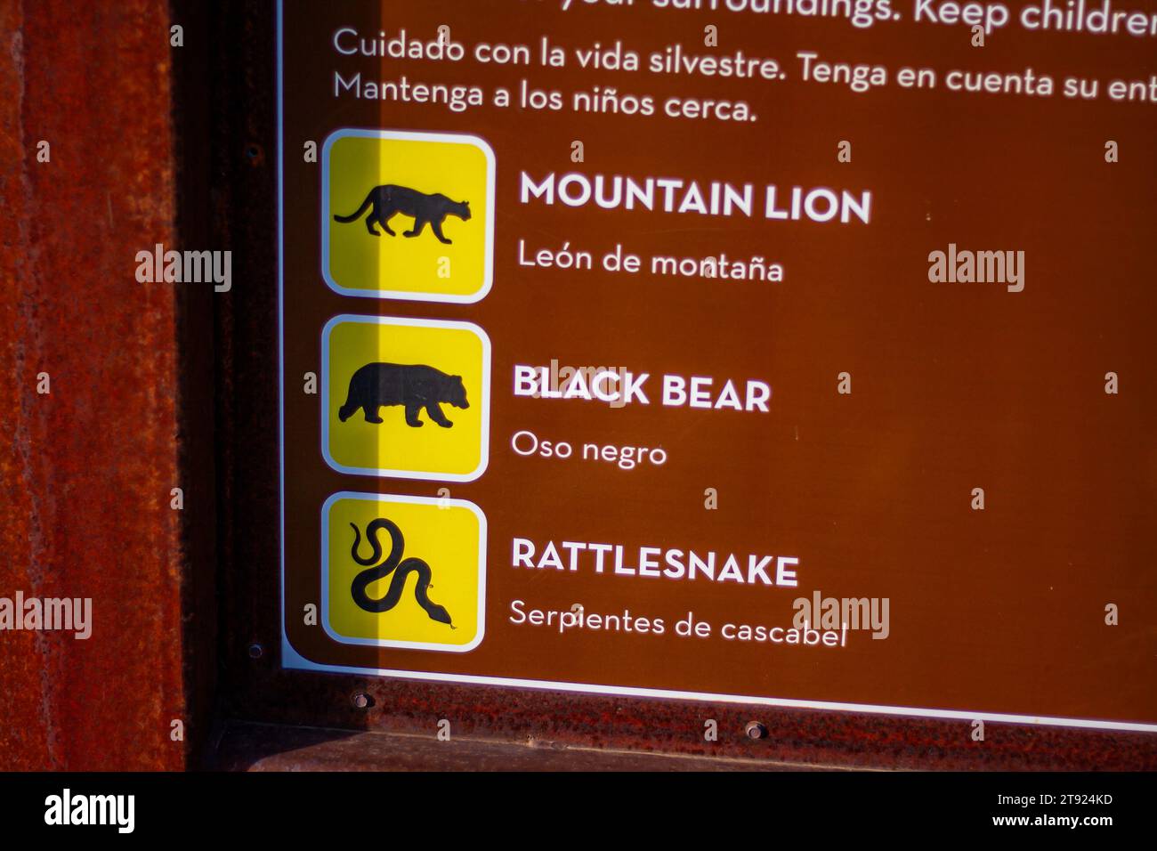 Cartello di avvertimento per la fauna selvatica in inglese e spagnolo, segnale di avvertimento bilingue nella natura selvaggia Foto Stock