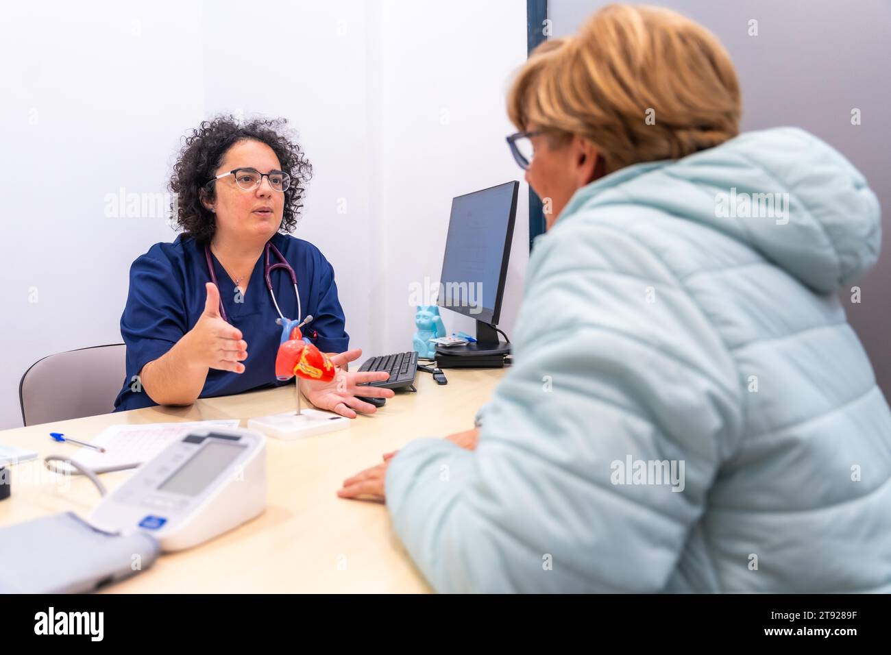 Medico cardiologo femminile presso la clinica di cardiologia che parla con un cliente Foto Stock