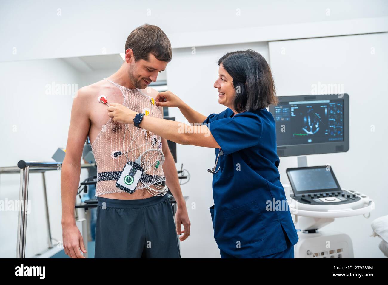 Medico donna che mette la maglia e i dispositivi per il test di cardiologia stress test in clinica Foto Stock
