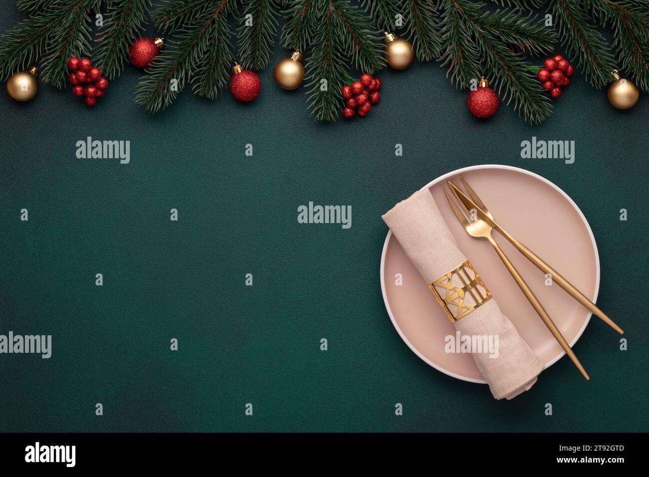 Vista dall'alto del tavolo di Natale: Piatto vuoto, posate dorate. Ambiente festivo, decorazioni per Capodanno. Baubles lucenti, rami di abete, alberi sempreverdi. Festeggiamenti Foto Stock