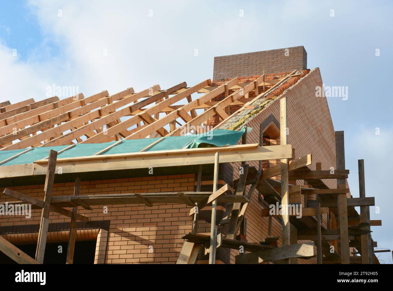 Costruzione di tetti di case con travi in legno, travi a capriate, strutture in legno e membrana antiumidità. Foto Stock
