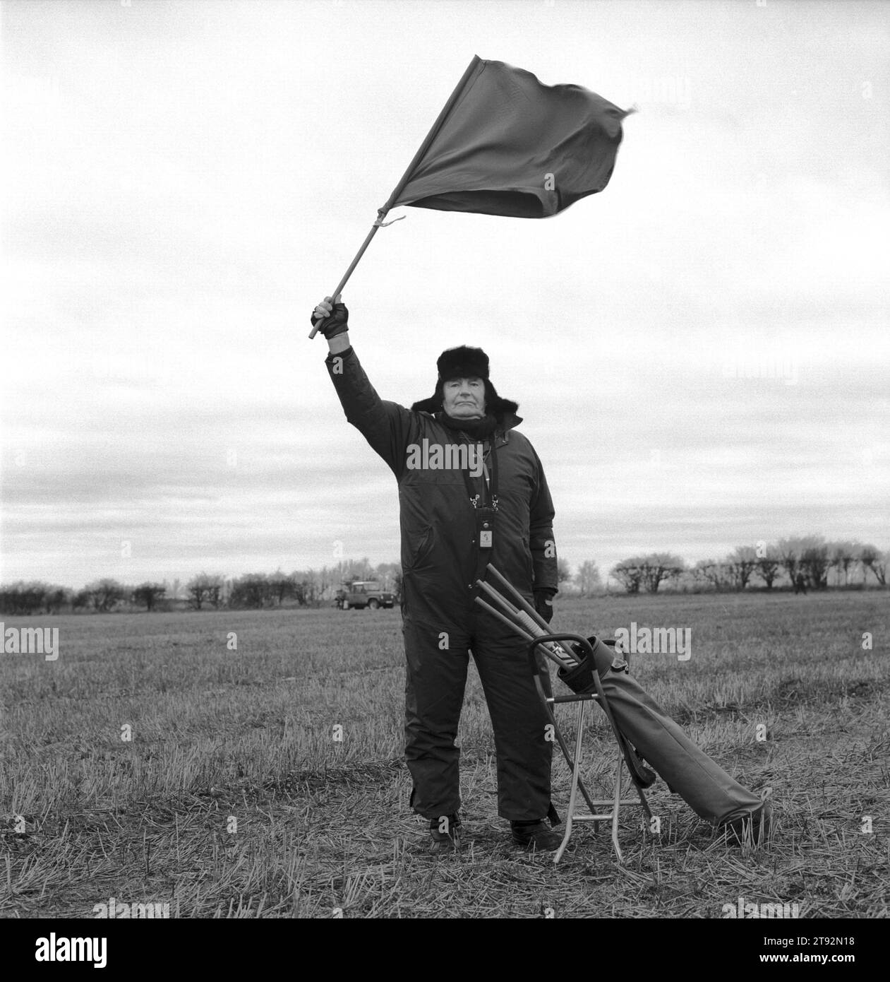 Hare Coursing 2000s UK. In un freddo giorno di febbraio i membri dello Swaffham Coursing Club si incontrano vicino a Narborough, Norfolk. Il giudice a cavallo controlla ogni percorso. Porta con sé una piccola bandiera rossa e bianca, che onda per indicare al flagman che greyhound ha vinto. Il flagman vola quindi la bandiera colorata appropriata. Inghilterra, anni '2000, HOMER SYKES Foto Stock