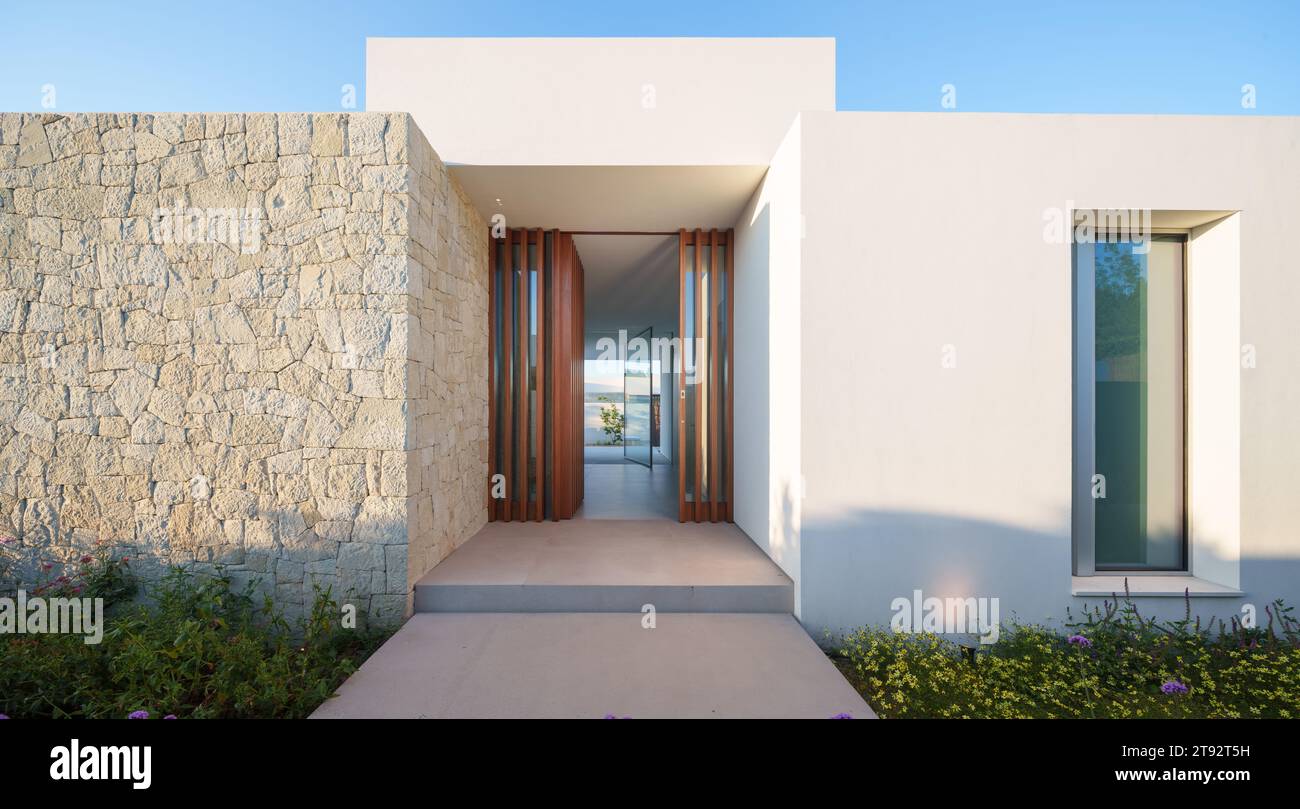 Una casa di lusso con una piscina minimalista e bianca e giardini potrebbe avere un design contemporaneo ed elegante Foto Stock