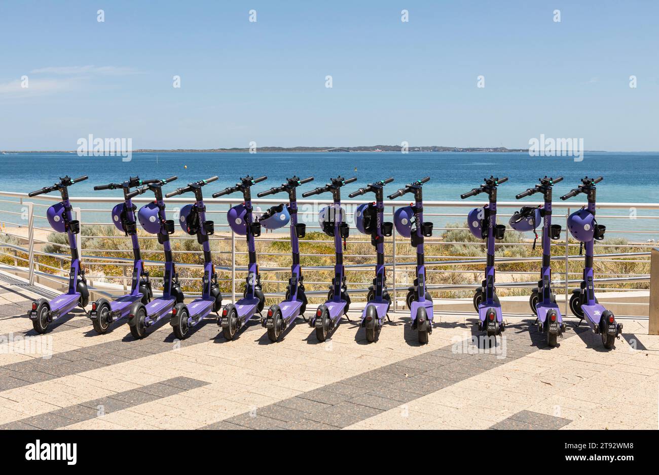 12 biciclette elettriche viola pronte per l'uso sul lungomare di Rockingham, vicino a Perth, Australia Occidentale. Foto Stock