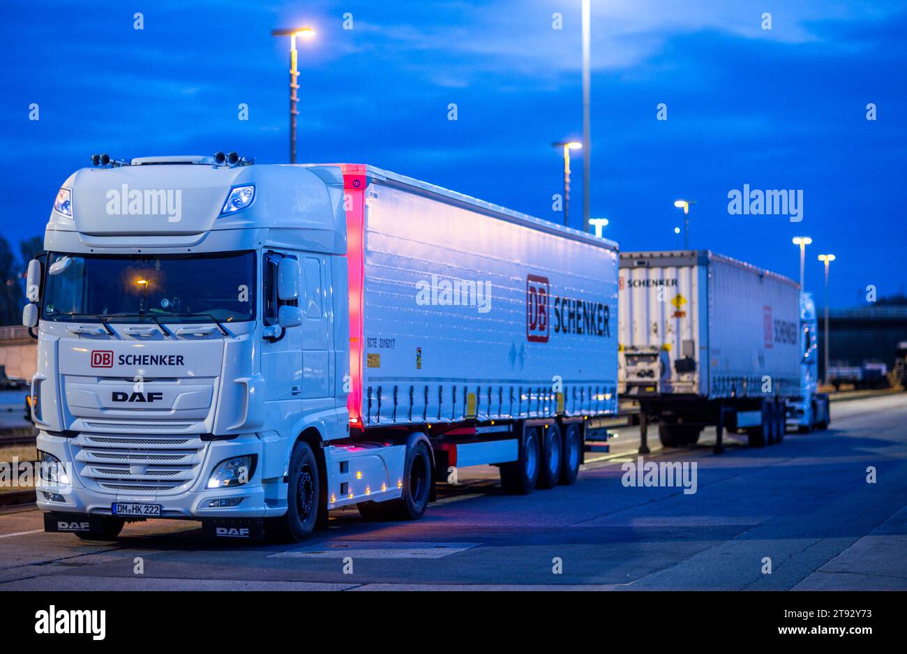Rostock, Germania. 21 novembre 2023. Al mattino, un veicolo con rimorchi dell'azienda di logistica DB Schenker si trova sul sito del centro logistico nel porto marittimo. La filiale logistica di Deutsche Bahn gestisce diversi centri logistici nel Meclemburgo-Pomerania. Credito: Jens Büttner/dpa/Alamy Live News Foto Stock