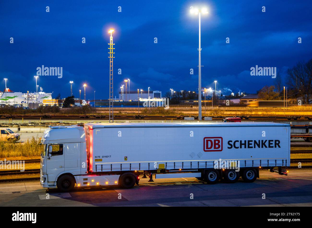 Rostock, Germania. 21 novembre 2023. Al mattino, un veicolo con rimorchi dell'azienda di logistica DB Schenker si trova sul sito del centro logistico nel porto marittimo. La filiale logistica di Deutsche Bahn gestisce diversi centri logistici nel Meclemburgo-Pomerania. Credito: Jens Büttner/dpa/Alamy Live News Foto Stock