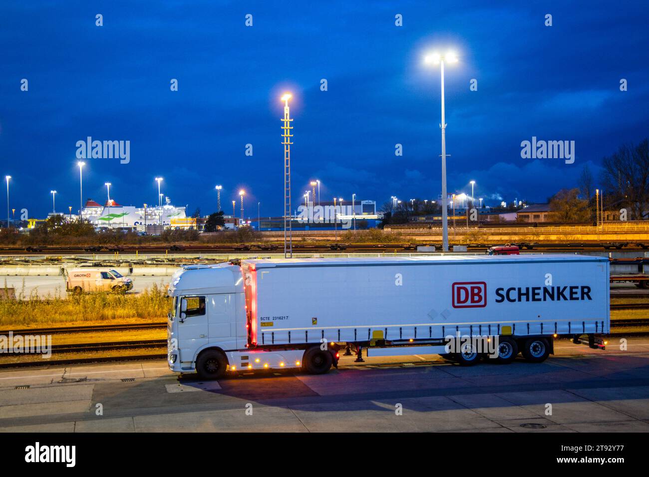 Rostock, Germania. 21 novembre 2023. Al mattino, un veicolo con rimorchi dell'azienda di logistica DB Schenker si trova sul sito del centro logistico nel porto marittimo. La filiale logistica di Deutsche Bahn gestisce diversi centri logistici nel Meclemburgo-Pomerania. Credito: Jens Büttner/dpa/Alamy Live News Foto Stock