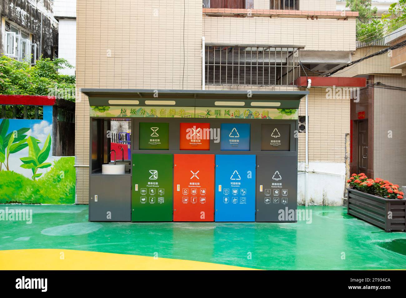 Zhongshan Cina-10 ottobre 2023: Contenitori per la raccolta dei rifiuti di colori diversi per la selezione dei rifiuti, vale a dire la cucina, rifiuti nocivi, altri e riciclabili. in un giardino a hor Foto Stock