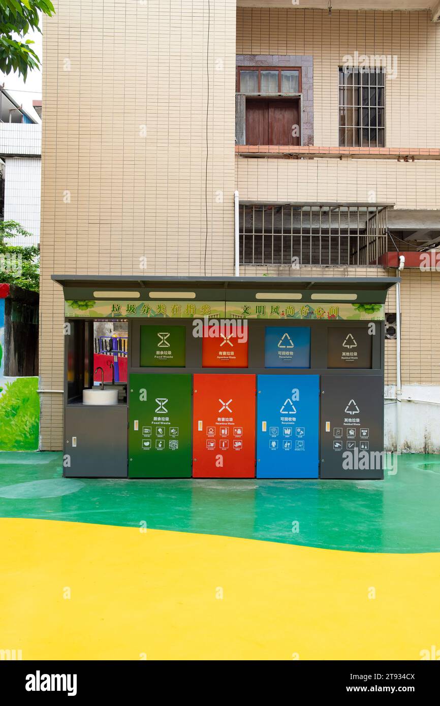 Zhongshan Cina-10 ottobre 2023: Contenitori per la raccolta dei rifiuti di colori diversi per la selezione dei rifiuti, vale a dire la cucina, rifiuti nocivi, altri e riciclabili. in un giardino a ver Foto Stock
