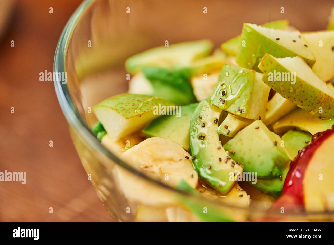 vista ravvicinata dell'insalata vegetariana con frutta fresca e miele con semi di sesamo, dieta a base vegetale Foto Stock