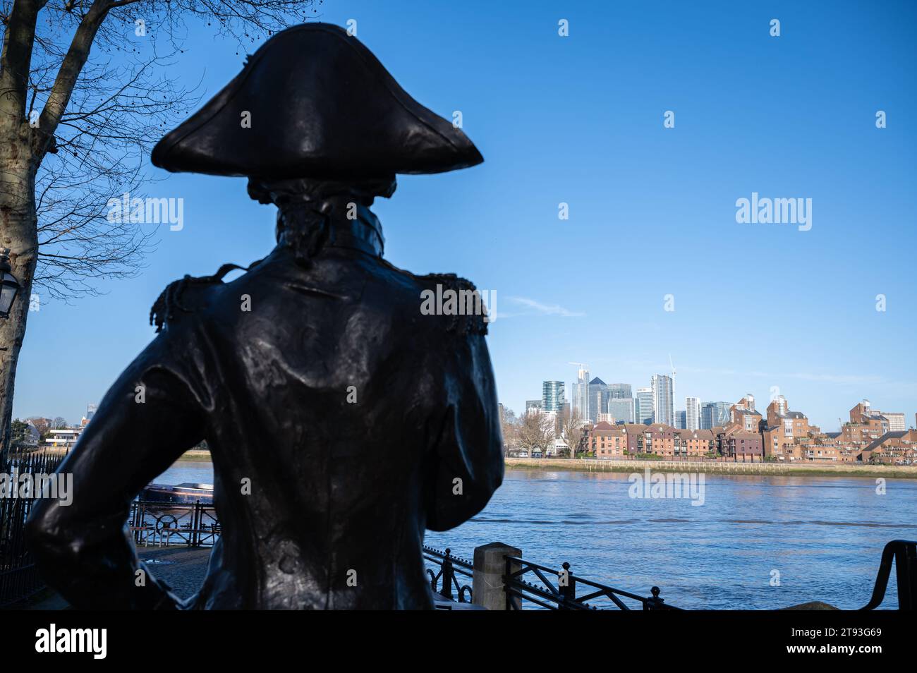 Una statua dell'ammiraglio Lord Nelson a Greenwich si trova guardando oltre il fiume Tamigi verso l'area dei Docklands sull'Isola dei cani, Londra, Regno Unito Foto Stock