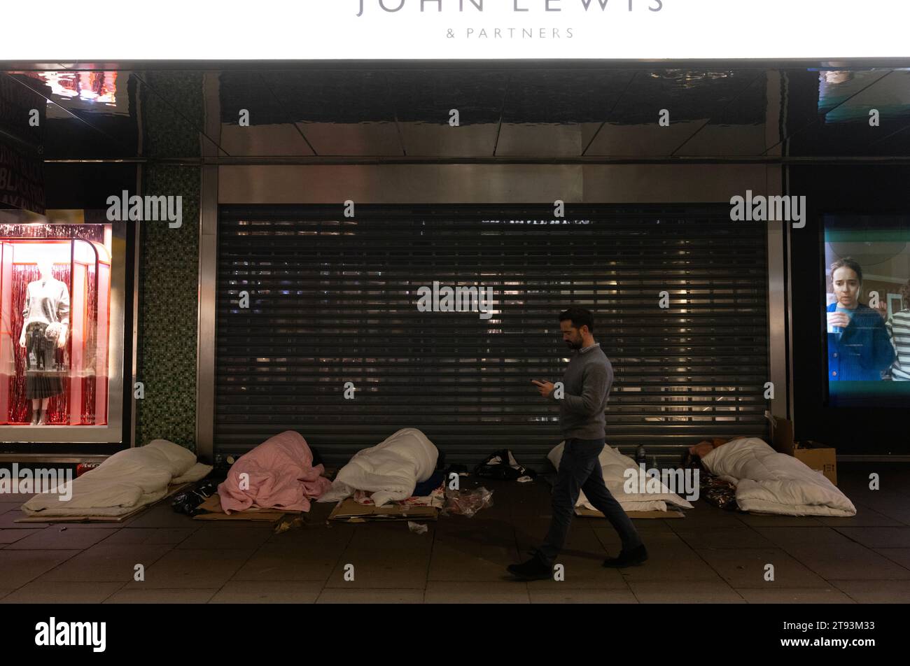 Senzatetto che dorme sul marciapiede fuori dai grandi magazzini John Lewis lungo Oxford Street, Londra, Inghilterra Foto Stock