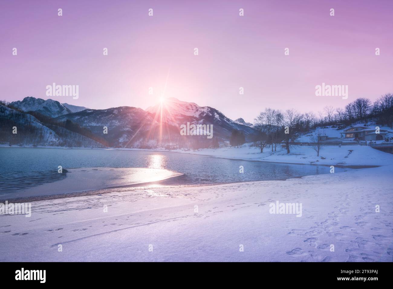 Lago Gramolazzo e neve sulle montagne Apuane in inverno al tramonto. L'ultima luce del giorno. Garfagnana, regione Toscana, Italia, Europa. Foto Stock