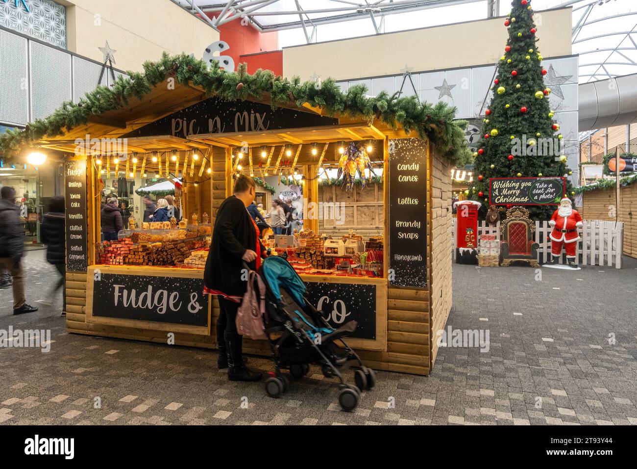 Centro commerciale Festival Place at Christmas, centro di Basingstoke, Hampshire, Inghilterra, Regno Unito. Bancarelle del mercatino di Natale e albero di Natale decorato Foto Stock
