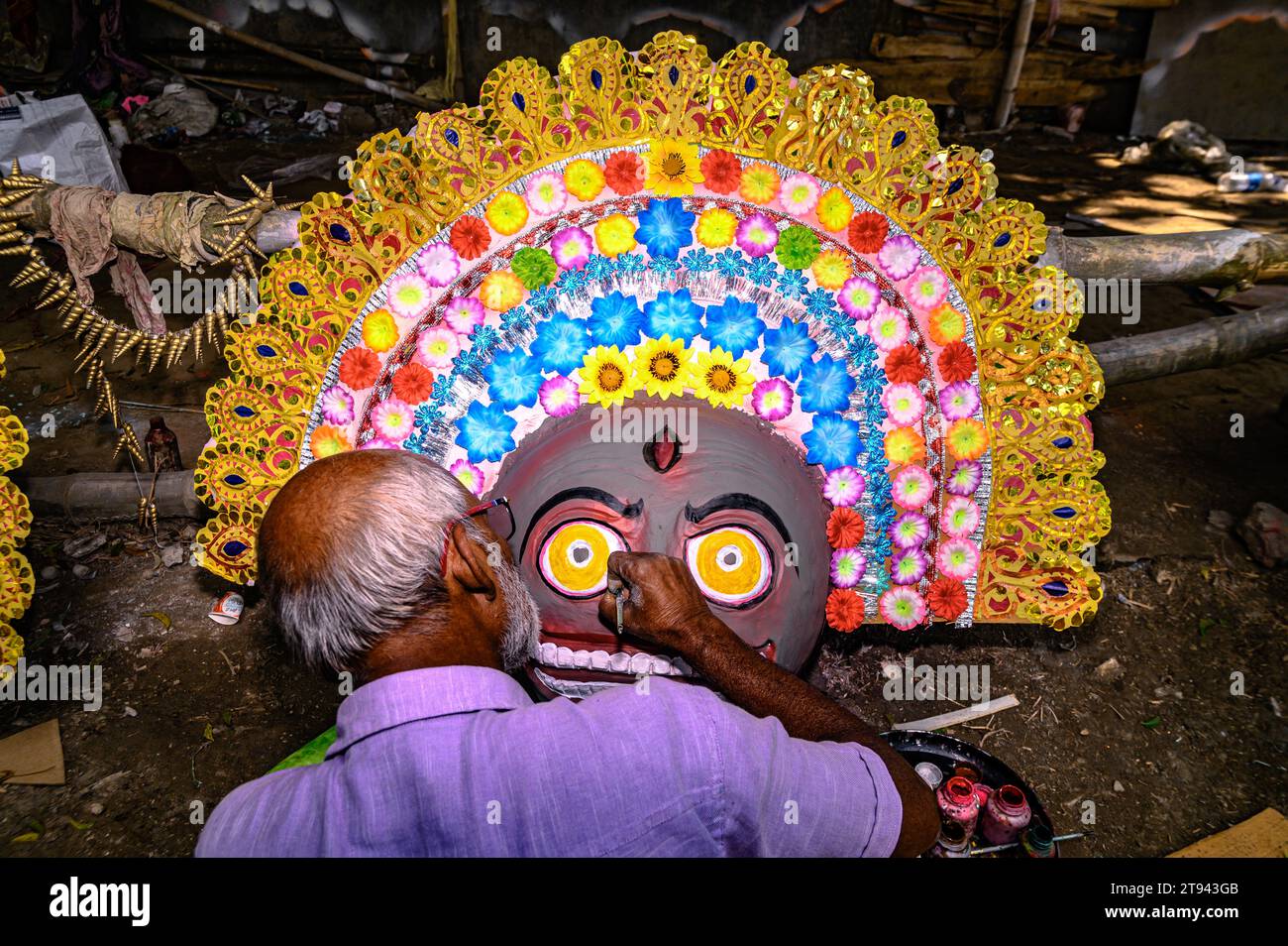 Un artista idolo del villaggio realizza grandi maschere colorate modellate sulle maschere di danza Purulia Chhau (la danza Purulia Chhau è elencata nella lista di danze patrimonio dell'umanità dell'UNESCO) di dee, animali e rakshasa (demoni umanoidi o spiriti ingiusti) come i personaggi della mitologia indù con l'argilla. L'artista poi dipinge gli idoli con il colore, per essere installato in un pandalo Jagaddhatri Puja. Tehatta, Bengala Occidentale, India. Foto Stock