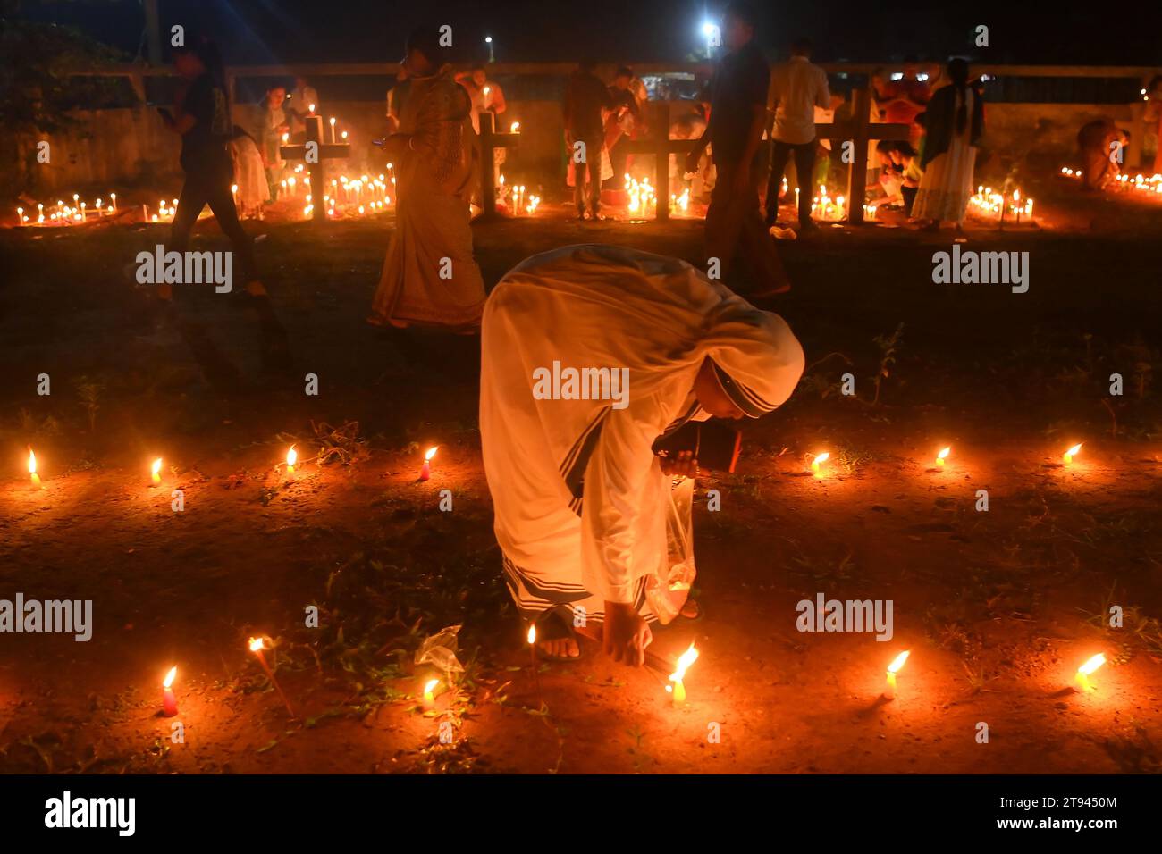 Le suore offrono preghiere accanto alle tombe dei loro familiari in un cimitero durante il "All Souls Day" alla periferia di Agartala. Tripura, India. Foto Stock