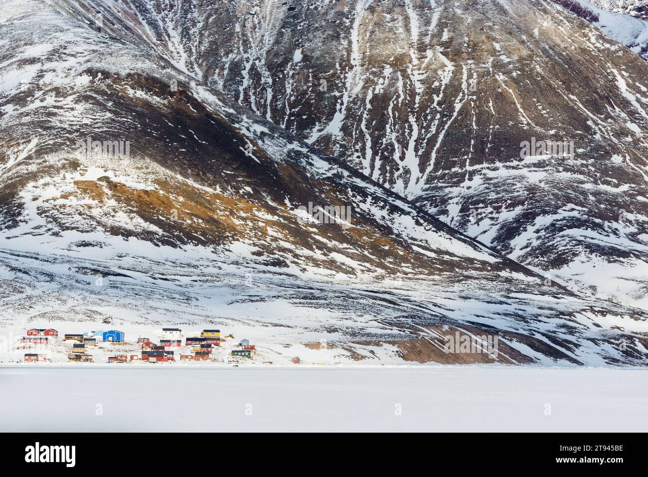 Villaggio di montagna innevato in Groenlandia in una fredda giornata invernale Foto Stock