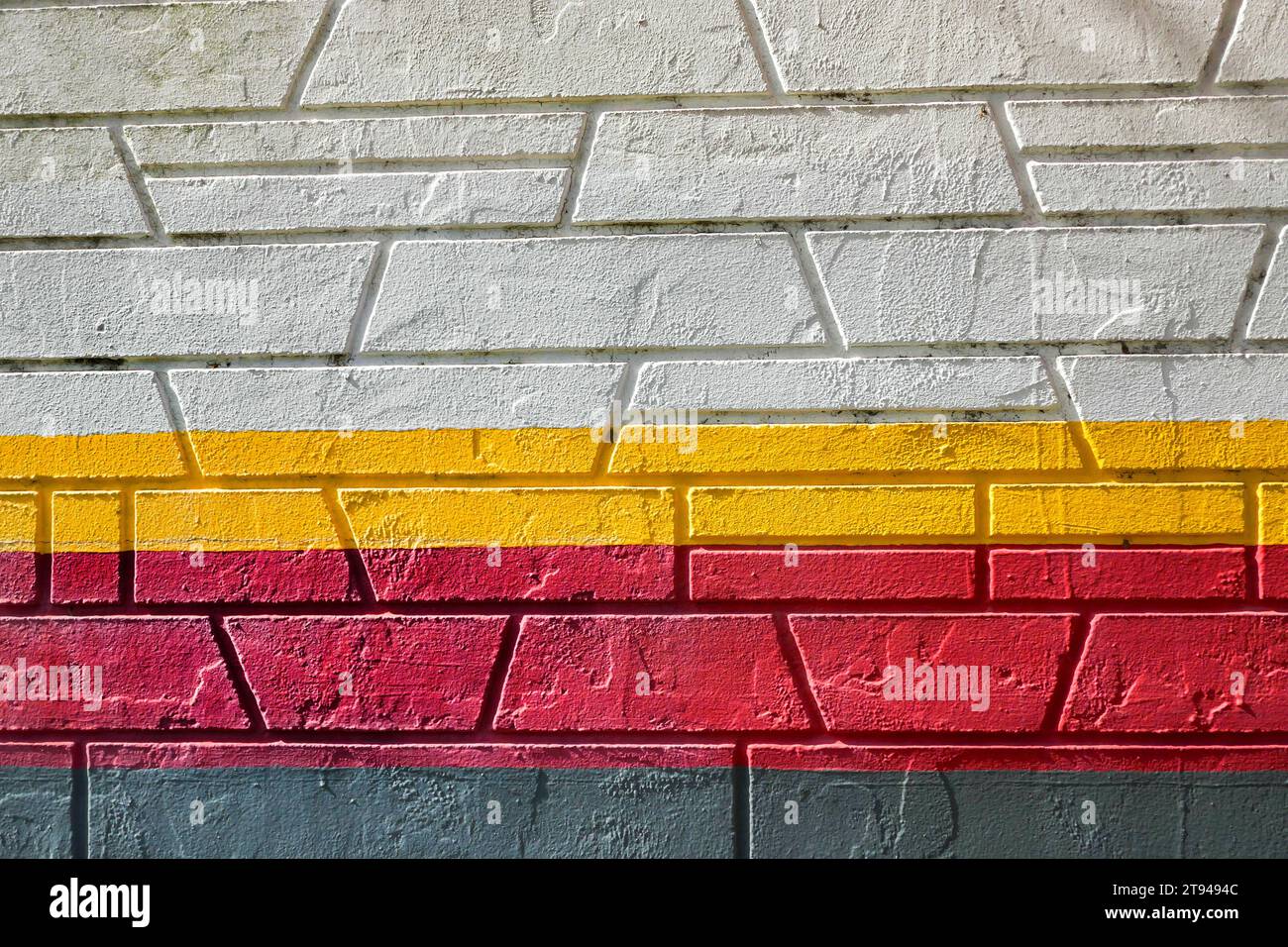 Il muro di mattoni di un'azienda dipinse colori diversi. Foto Stock