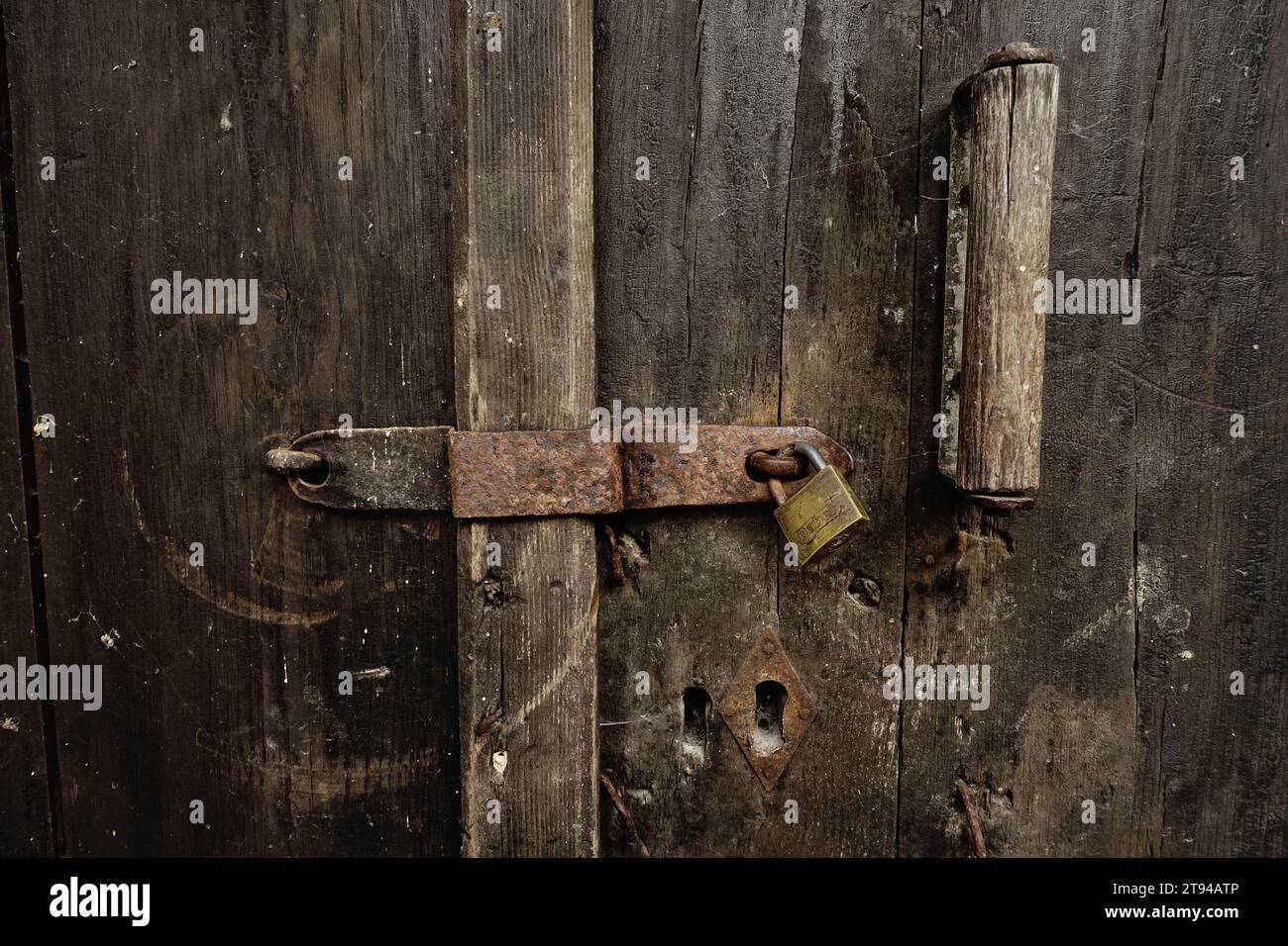 Una vecchia serratura in ferro con un lucchetto su una porta di legno intemprata nel Monastero di Raca, Serbia Foto Stock