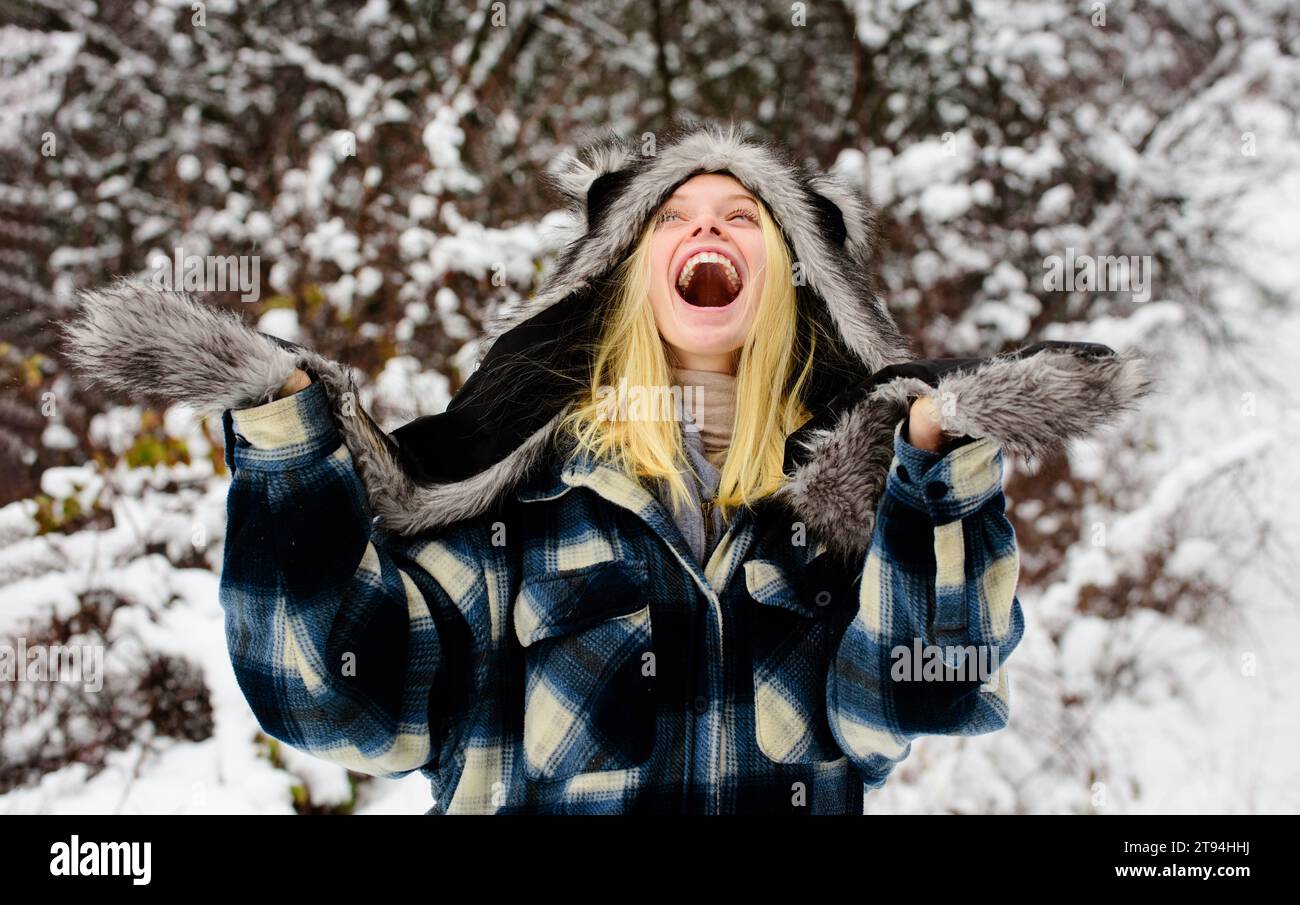 Ragazza della moda d'inverno. Inverno freddo. Bella donna felice nel parco invernale innevato con abiti caldi. Sorridente ragazza invernale in cappotto a quadri, pelliccia Foto Stock