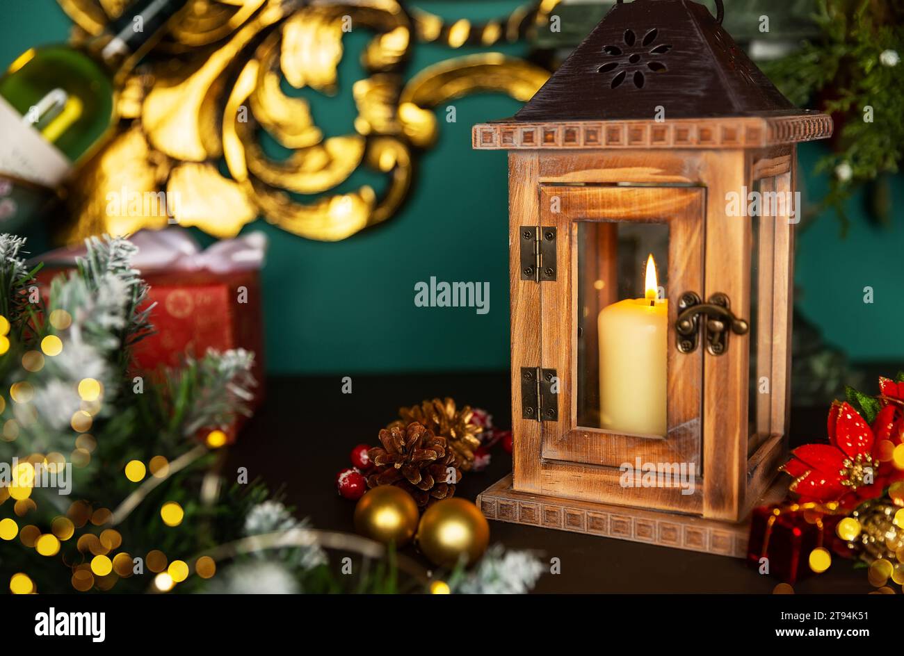 Biglietti d'auguri per le festività con la scena natalizia. Lanterna con candele e decorazioni natalizie su un vecchio tavolo di legno Foto Stock